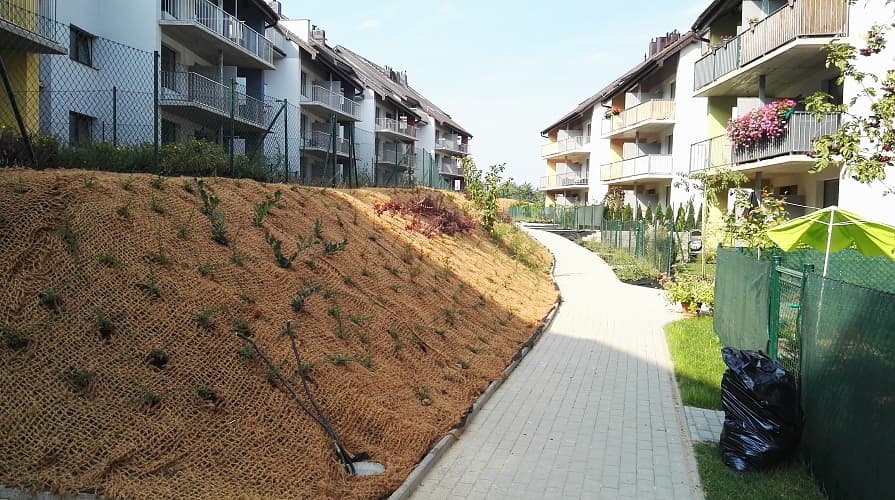 Kokosnetz an der Böschung rund um ein Mehrfamilienhaus